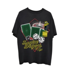 Black Imagine Dragons "Live in Vegas" t-shirt featuring a vibrant casino-inspired design with playing cards, dice, poker chips, a roulette wheel, and a cowboy figure. The band's name is displayed in bold yellow lettering with a retro Vegas-style font.